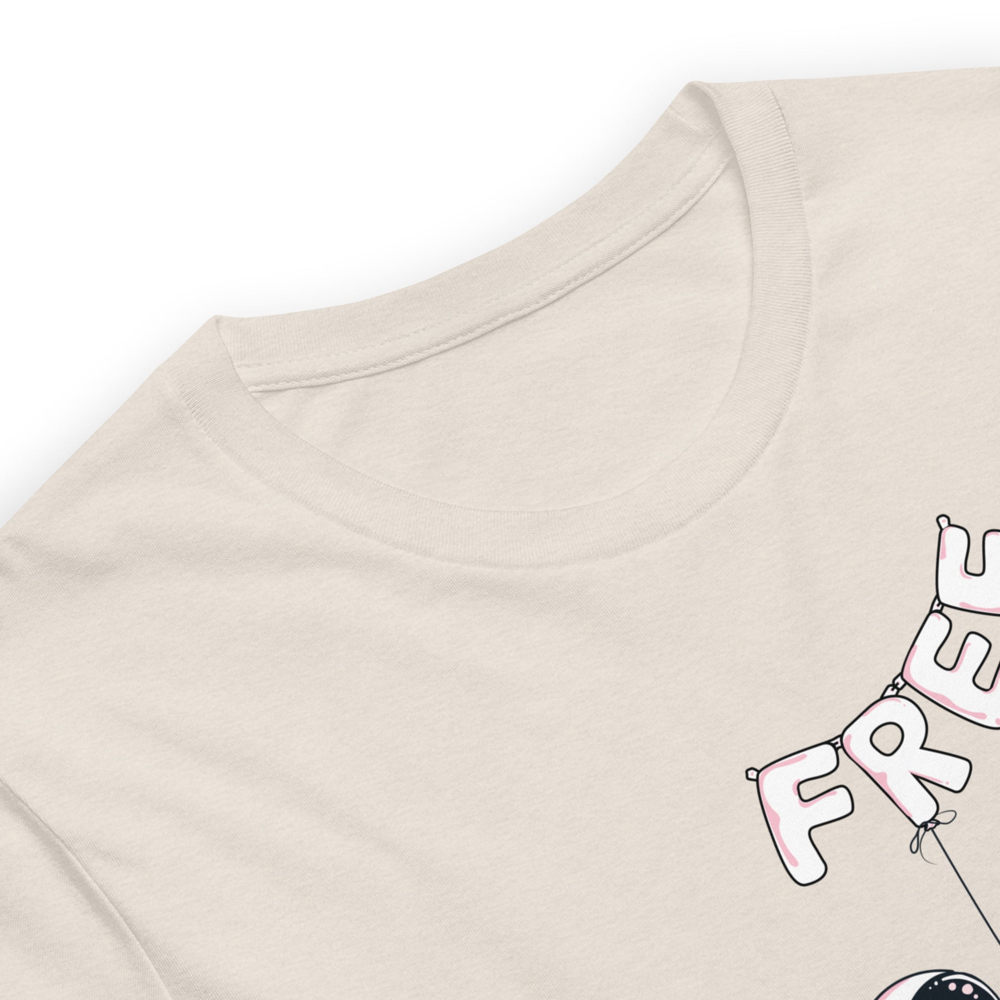 Heather dust color tee with an alien holding balloons that spell the word free close up