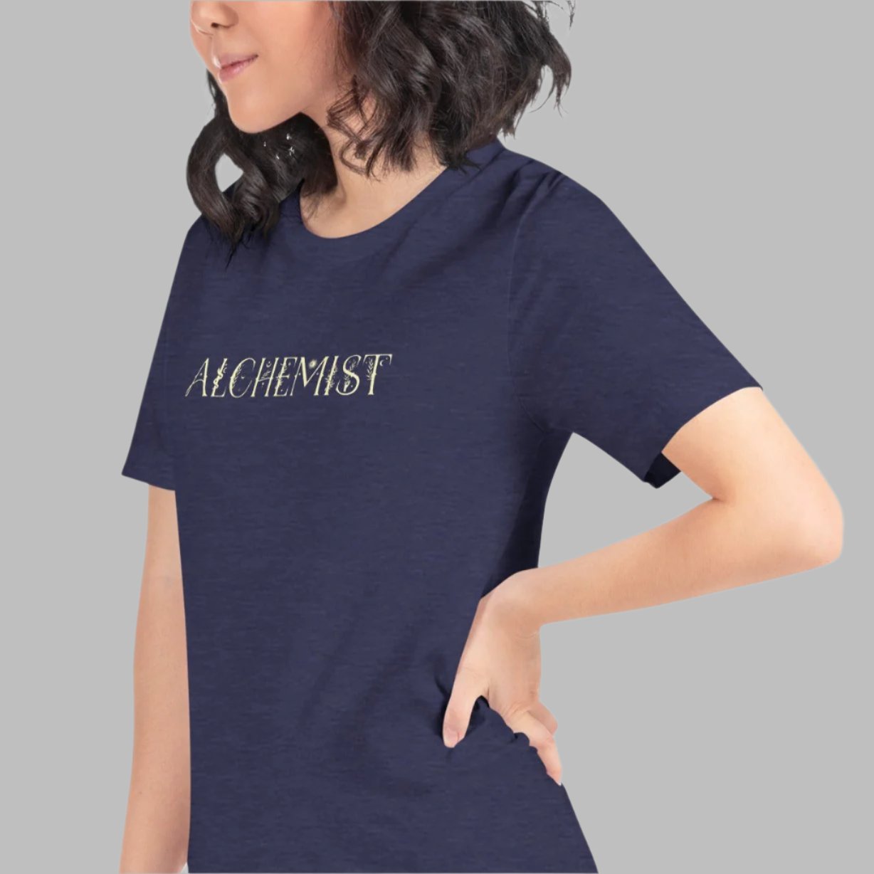 Midnight navy color heather tee that says Alchemist in descriptive light yellow type on model